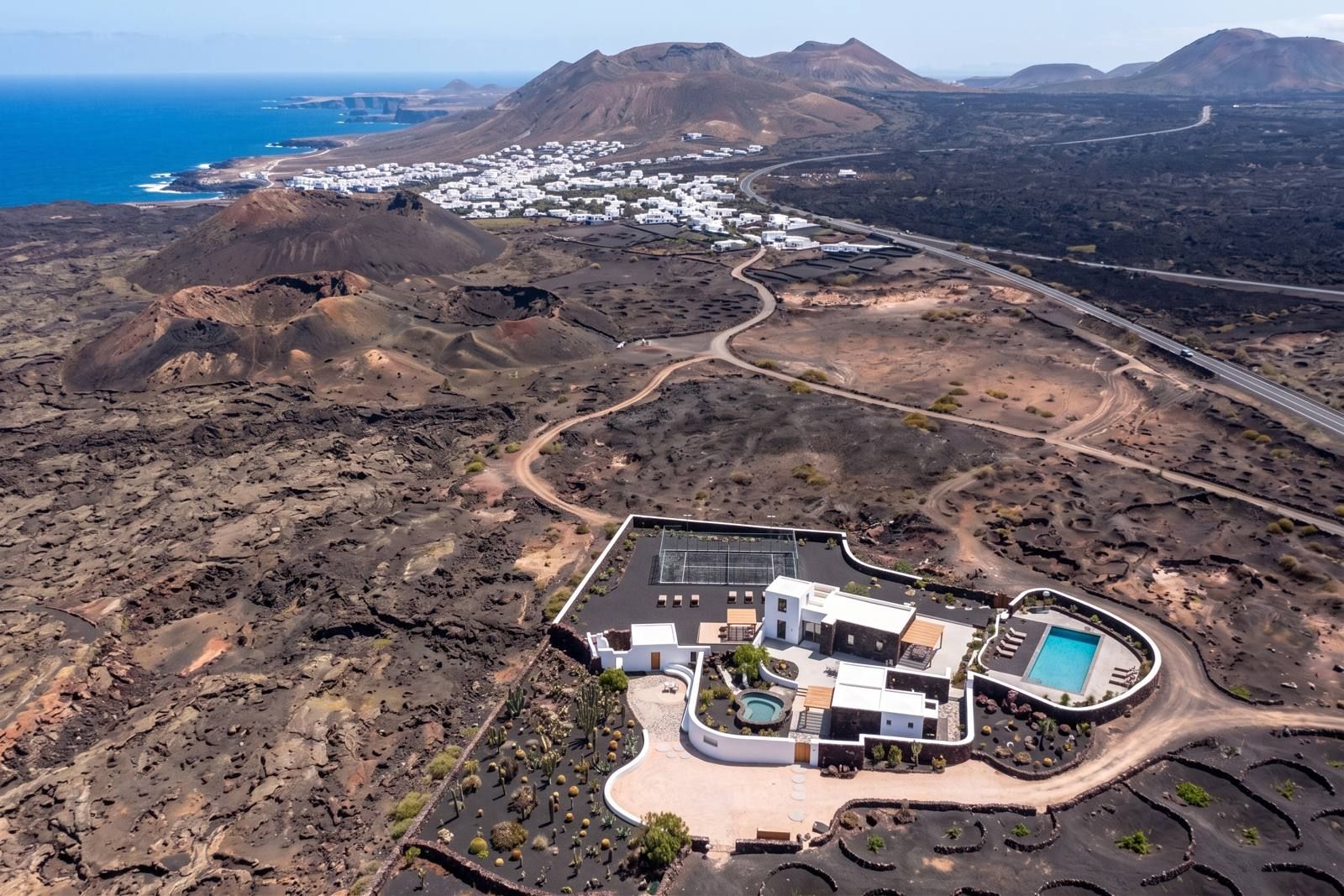 From above — Aerial visualisation of the estate in the volcanic landscape, with the Atlantic and the village behind it.